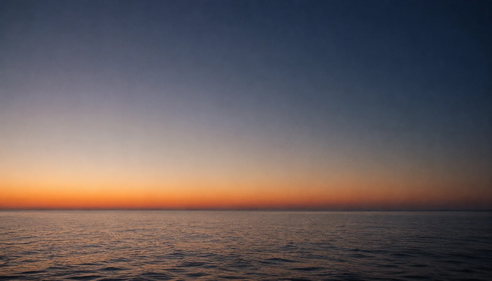 Il mare di Sicilia all'imbrunire, orizzonte tra blu profondo e ambra
